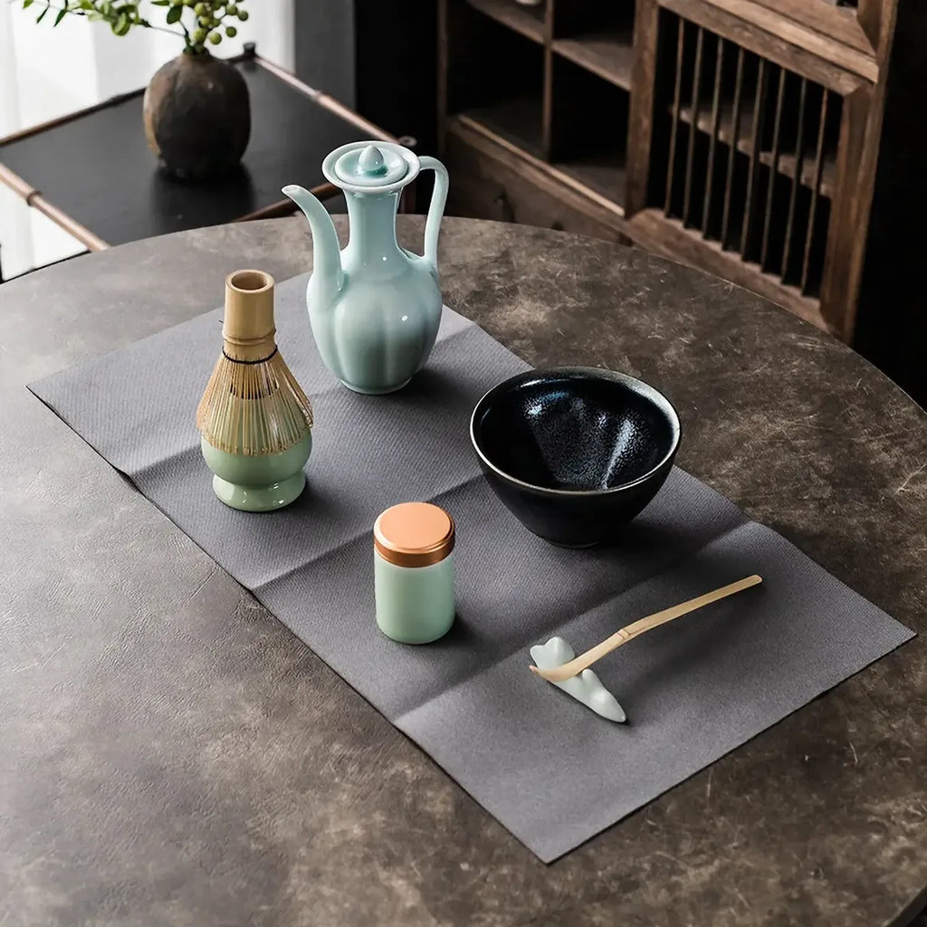 Set matcha Chado bol noir dispose sur la nappe avec verseuse et accessoires