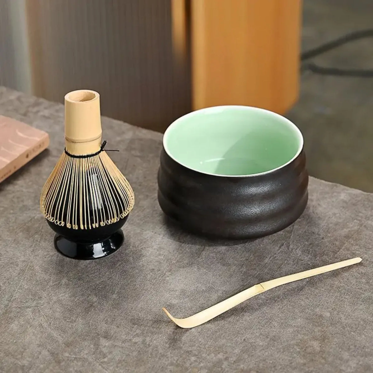 Vue du bol noir céladon avec chasen et chashaku du set matcha Mugon