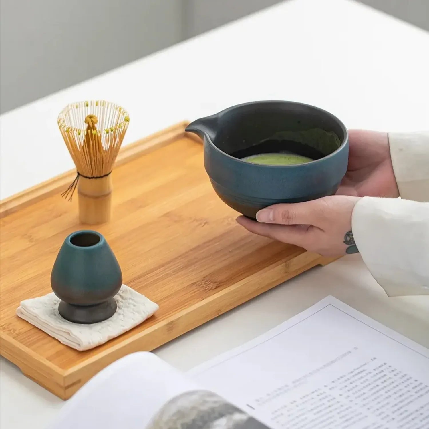 Main tenant le bol noir du set matcha Shizuku avec fouet bambou Image
