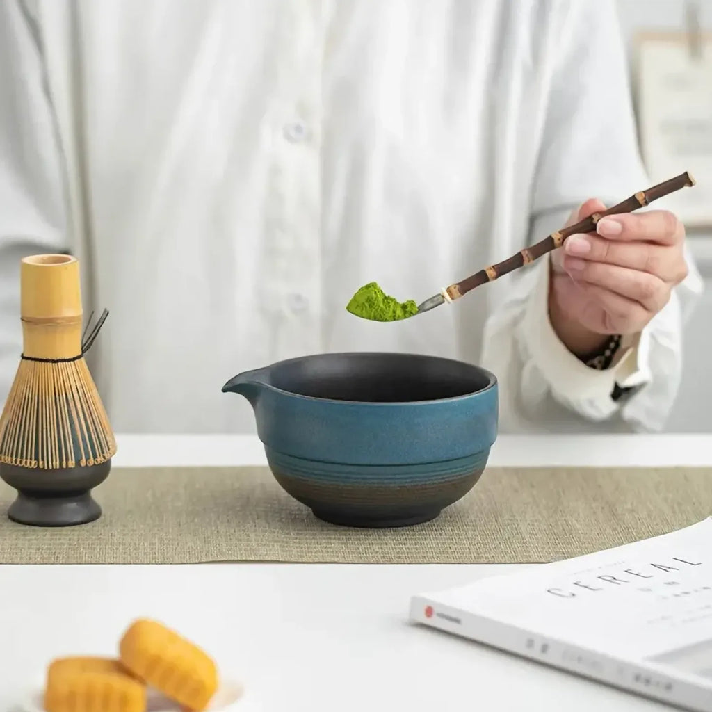 Geste de préparation avec chashaku au-dessus du bol bleu du set matcha Shizuku