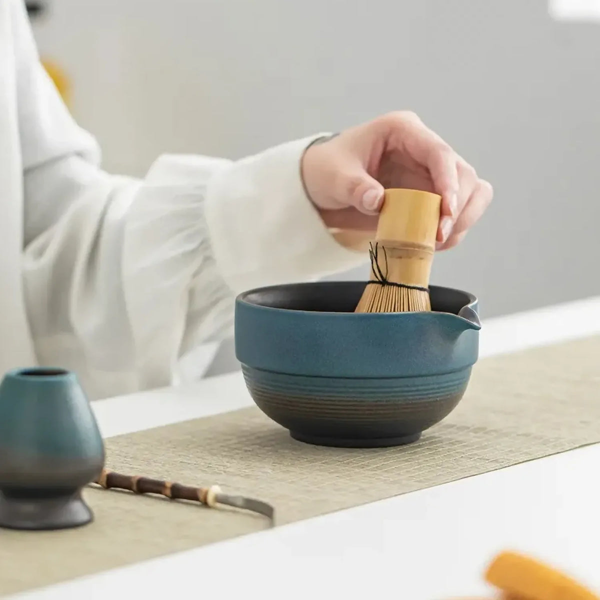 Geste de préparation avec fouet sur le bol bleu indigo du set matcha Shizuku