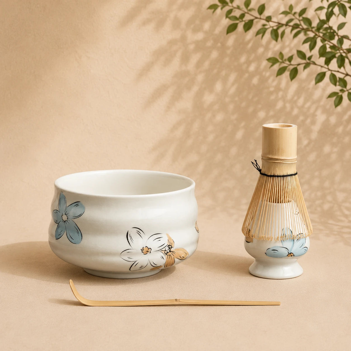 Set matcha Tsubaki coloris blanc nacre fleuri - bol chawan blanc motifs floraux bleus et chasen bambou sur fond beige
